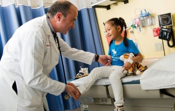 лекар прегледува дете со артроза на колкот